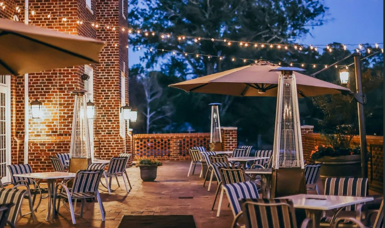 outdoor patio with tables, chairs, umbrellas and lights